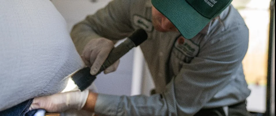 Worker inspecting a bed for bed bugs in Silverdale, WA.