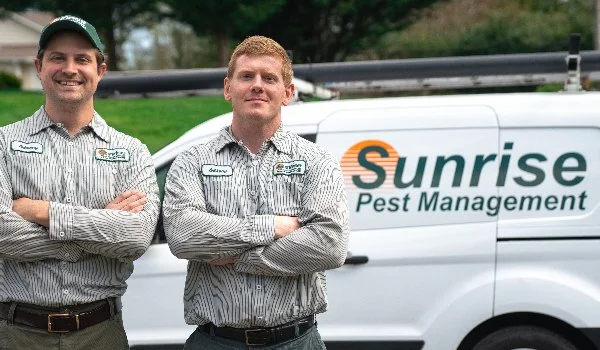 Sunrise Pest & Turf Management van and employees in front of commercial property in Bainbridge Island, WA.