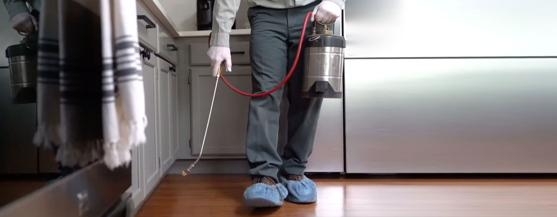 Technician performing indoor spider control treatment