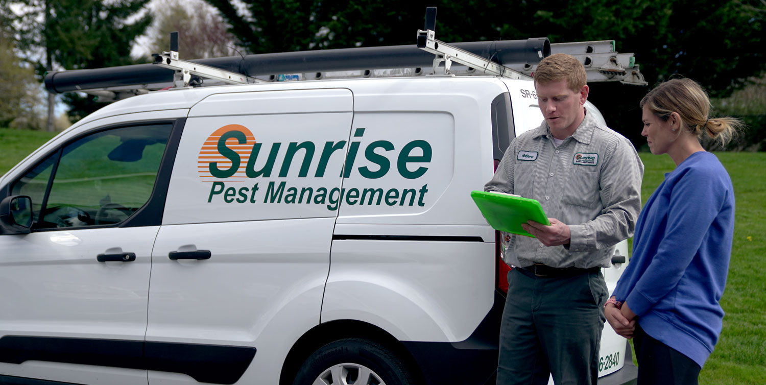 Sunrise Pest & Turf Management technician consulting with customer