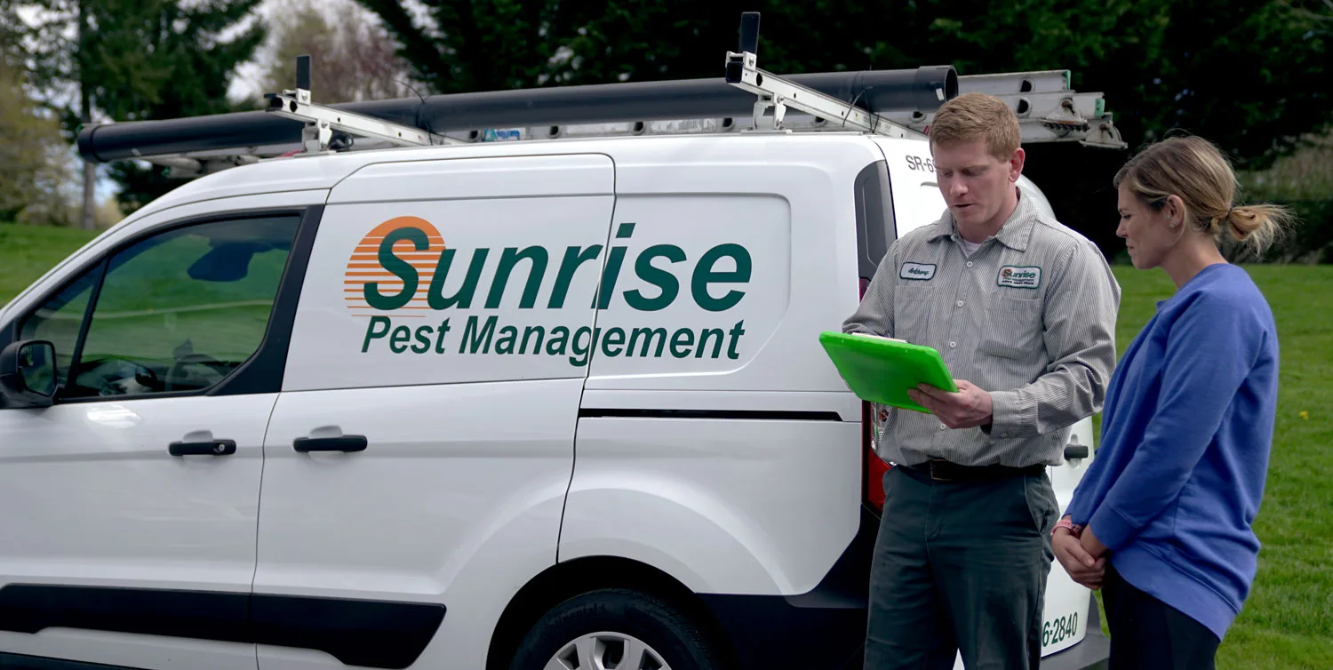 Sunrise Pest & Turf Management technician consulting with customer